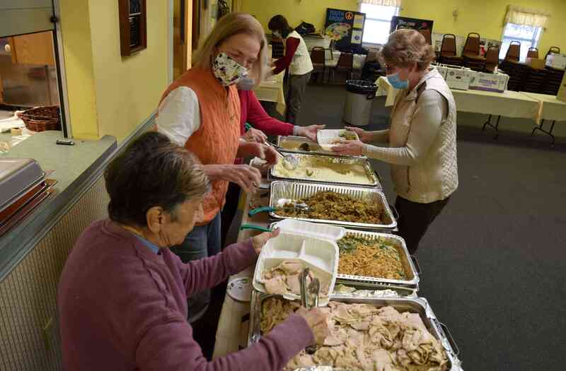 From left: St. Michaels Community Center volunteers Ange Oteri, Karen Shook, Betsy Petty (partially hidden), and Marsha Kacher work together to package Thanksgiving meals for take-out, while volunteer Agnes Kedmenecz packages up utensils in the background. St. Michaels Community Center staff and volunteers packaged 173 meals along with numerous boxes of fresh produce and pantry items for delivery and pick up at its annual Community Thanksgiving Dinner on Wed., Nov. 25. 