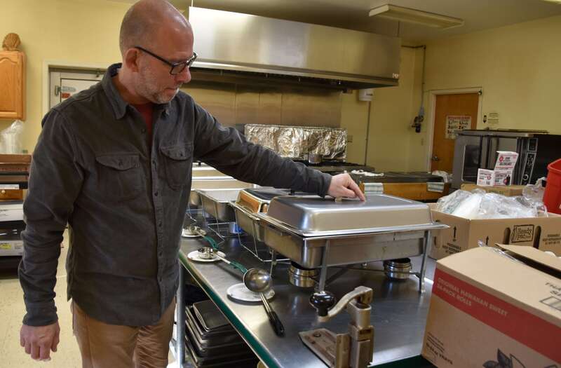St. Michaels Community Center Executive Director Patrick Rofe helps to set out chafing dishes to keep Thanksgiving dinner warm at the nonprofit’s Nov. 25 Community Thanksgiving Dinner. The St. Michaels Community Center is also hosting a Christmas toy and household item drive, with donated items dropped off no later than Dec. 20 at Treasure Cove Thrift Shop Mondays through Saturdays from 10:00 a.m. to 2:00 p.m. 